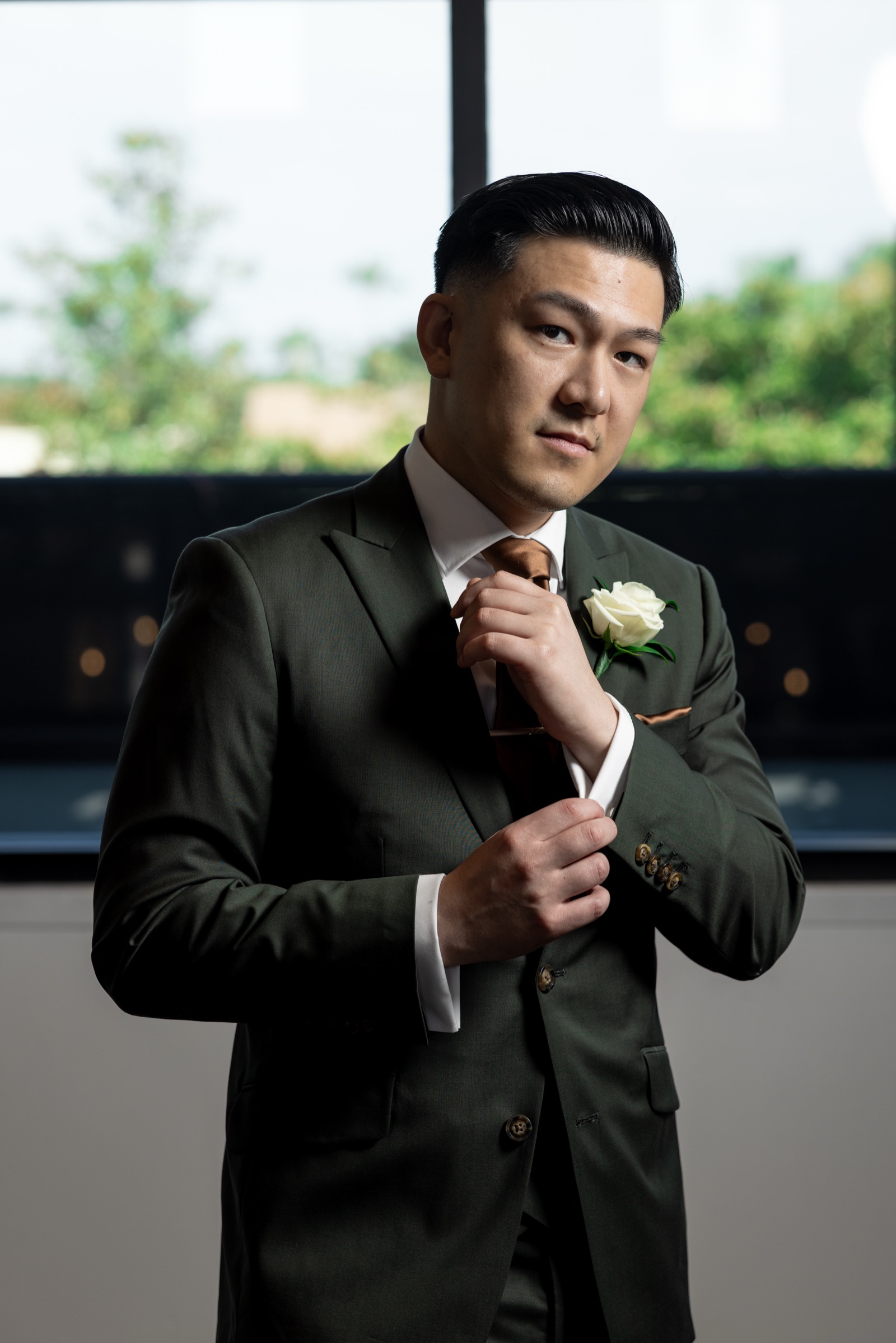 Kevin adjusting his copper tie, groom getting ready at The Colony House