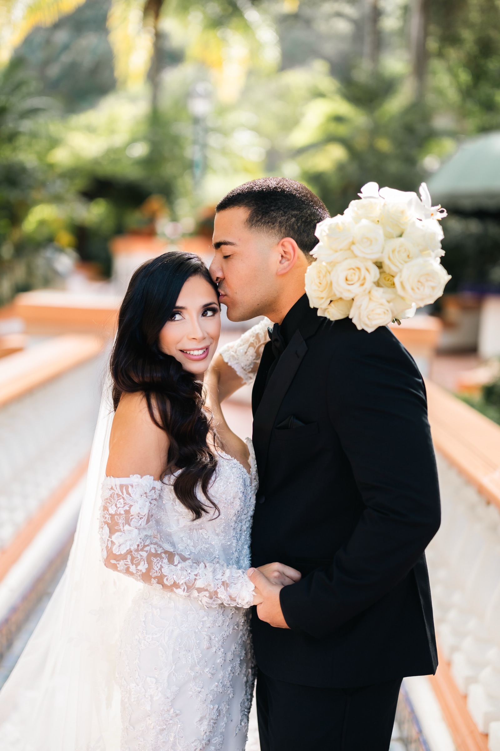 Mikey kissing Michelle on the forehead with bouquet at Rancho Las Lomas