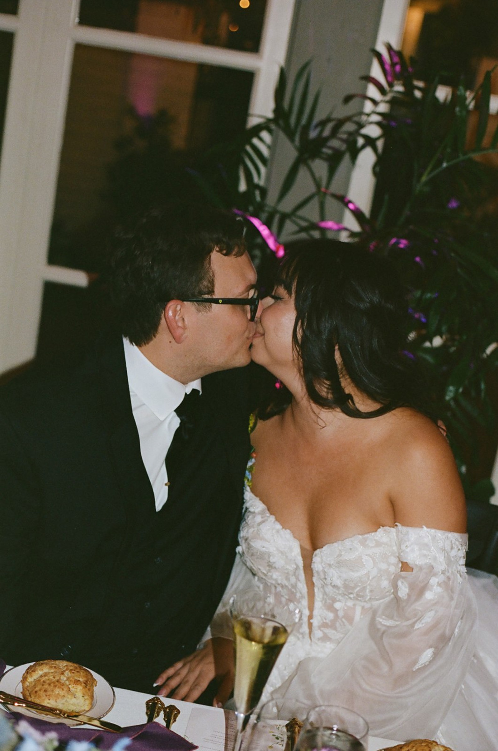 Janet and Ryan sharing a kiss at their reception, captured on film