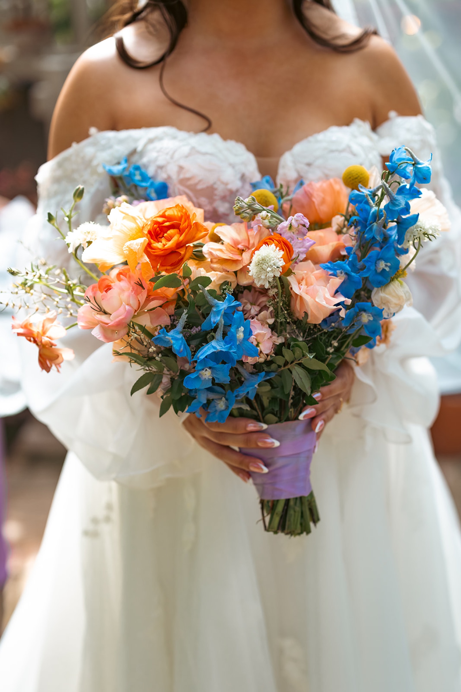 Janet's colorful bridal bouquet with blue, orange, and pink flowers