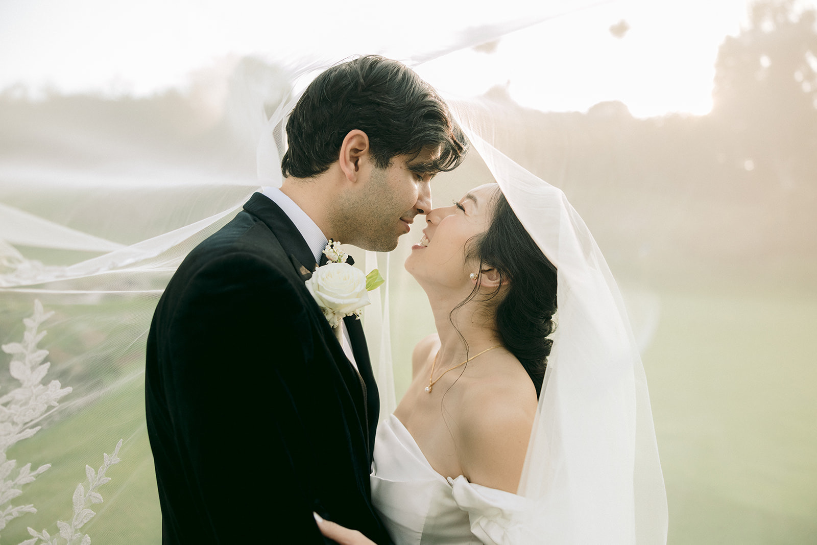 Intimate couple portrait under veil at golden hour