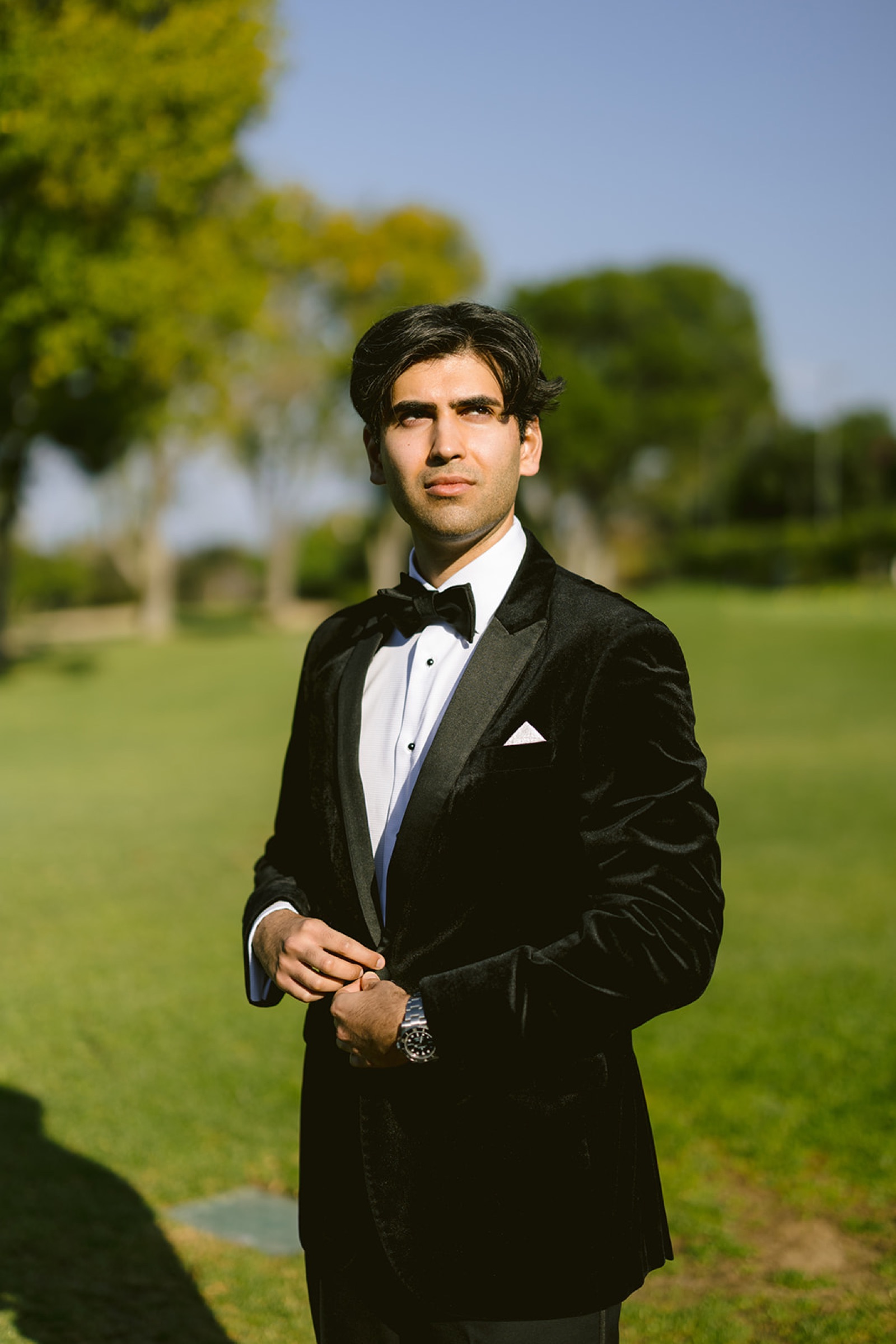 Groom looking back at bride on the golf course