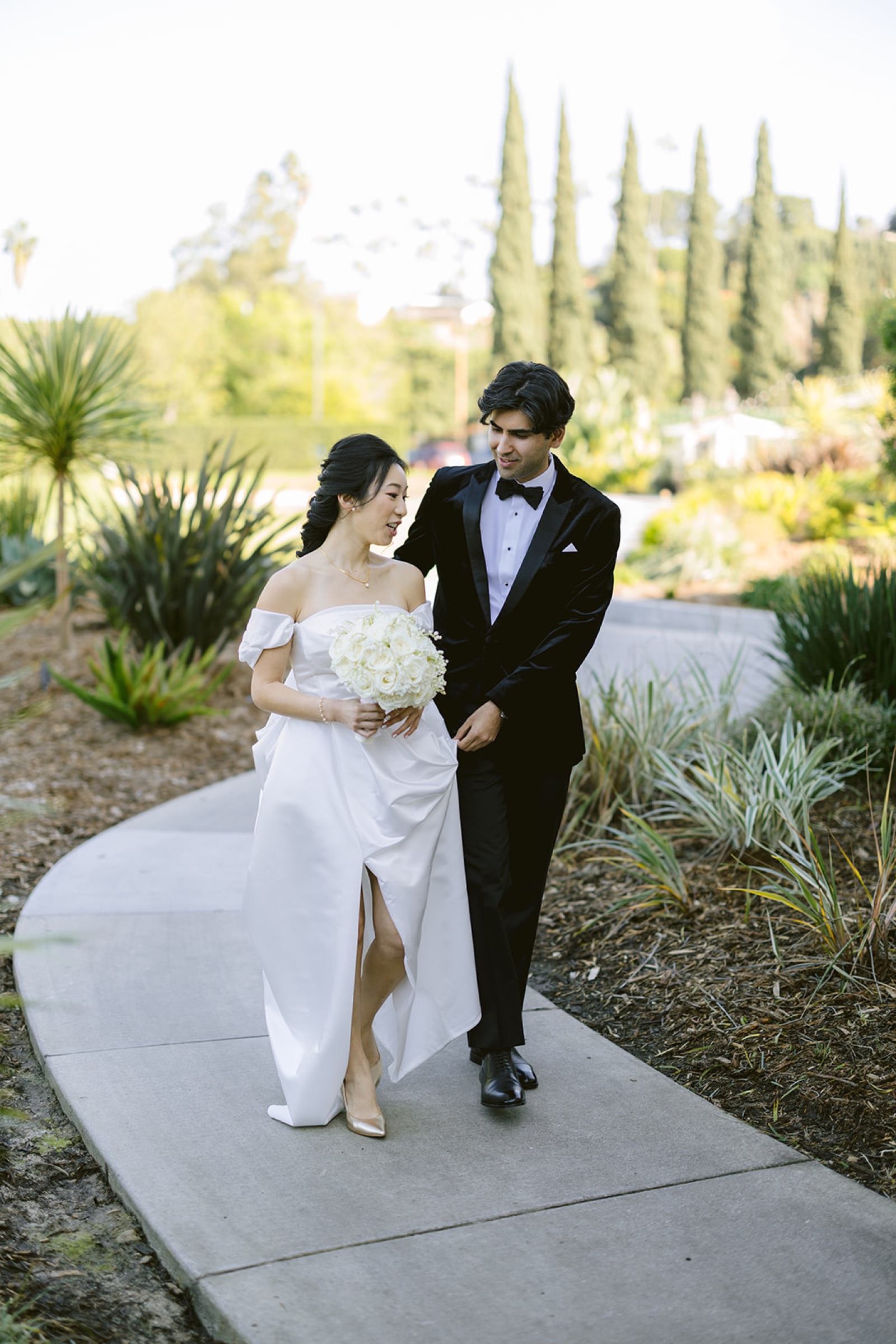 Couple walking arm in arm through the gardens