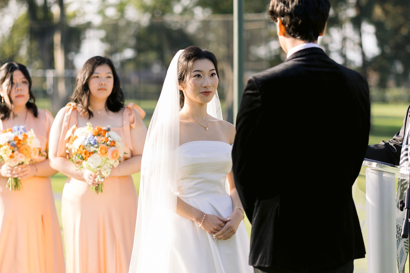 Bride looking at groom during vows with bridesmaids