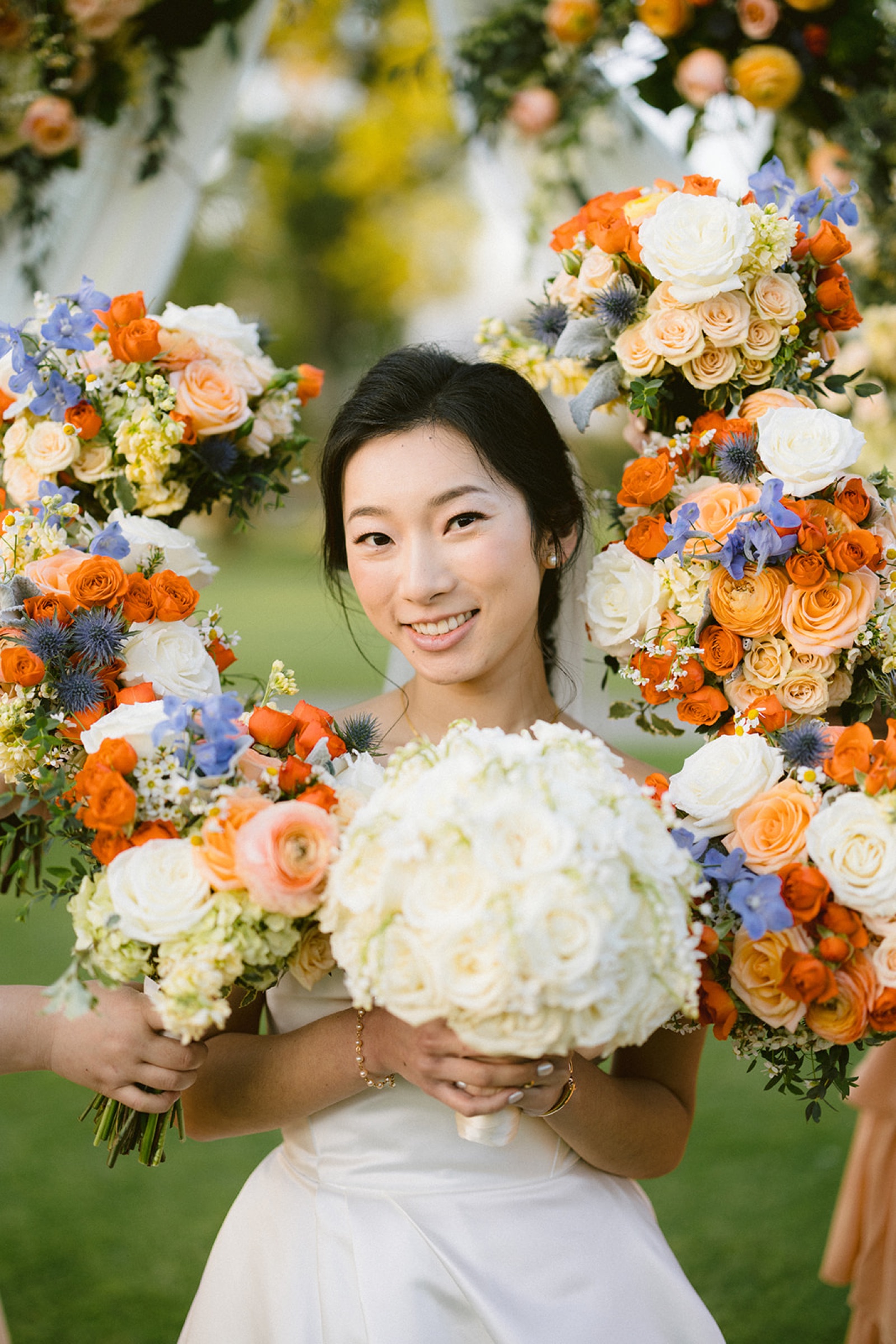 Bride surrounded by bouquets after ceremony